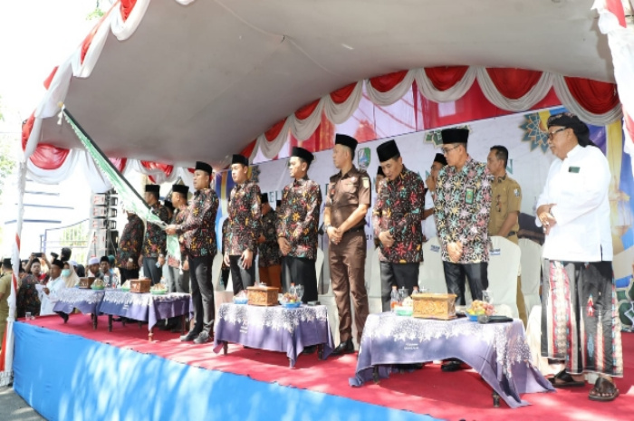 Bupati Sampang H. Slamet Junaidi mengangkat bendera bersama Wabup Sampang serta Forkopimda dan jajaran Pemkab Sampang berdiri melepas CJH Sampang.
