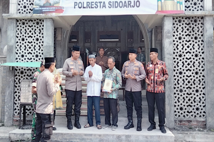 Kapolresta Sidoarjo Kombespol Kusumo Wahyu Bintoro menyerahkan bantuan semen dan Al Qur'an pada takmir Masjid Miftakhul Jannah Wedoroklurak