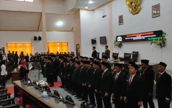 45 anggota DPRD Sampang berdiri berjejer menhadap ke tamu undangan ketika mengikuti proses pelantikan dan pengambilan sumpah jabatan di Gedung Graha Paripurna DPRD Sampang, pada Senin (26/8/2024).